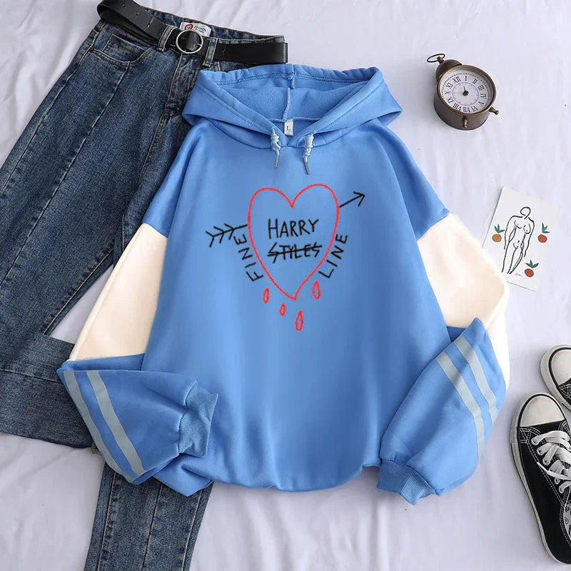 Blue and white hoodie with heart and arrow graphic, text 'Harry Styles Fine Line', paired with jeans and sneakers