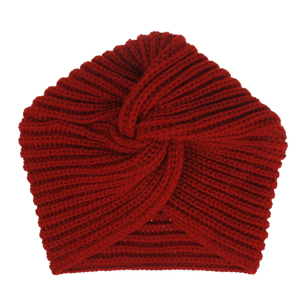 Close-up of a red knitted winter turban headband with twisted front design