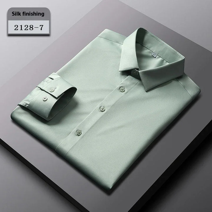 Folded light green silk finished dress shirt with buttoned cuffs on gray surface, labeled 2128-7