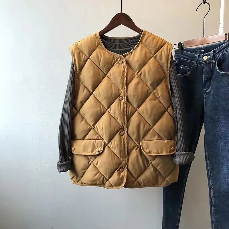 quilted tan sleeveless vest over gray ribbed long sleeve shirt, paired with dark blue jeans on hangers