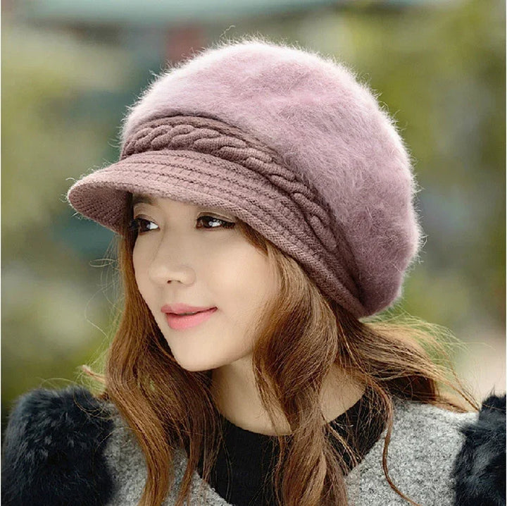 Woman wearing a soft pink wool beret with braided detail and a short brim, styled with wavy hair