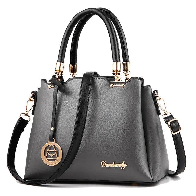 Elegant black leather handbag with gold hardware, dual handles, and detachable shoulder strap
