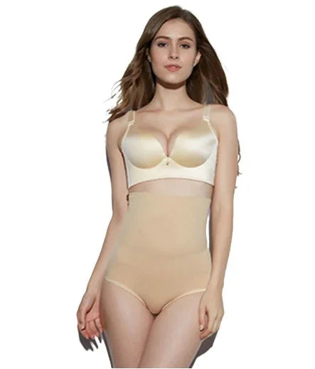 woman wearing beige high-waisted shaping underwear and satin beige bra on white background