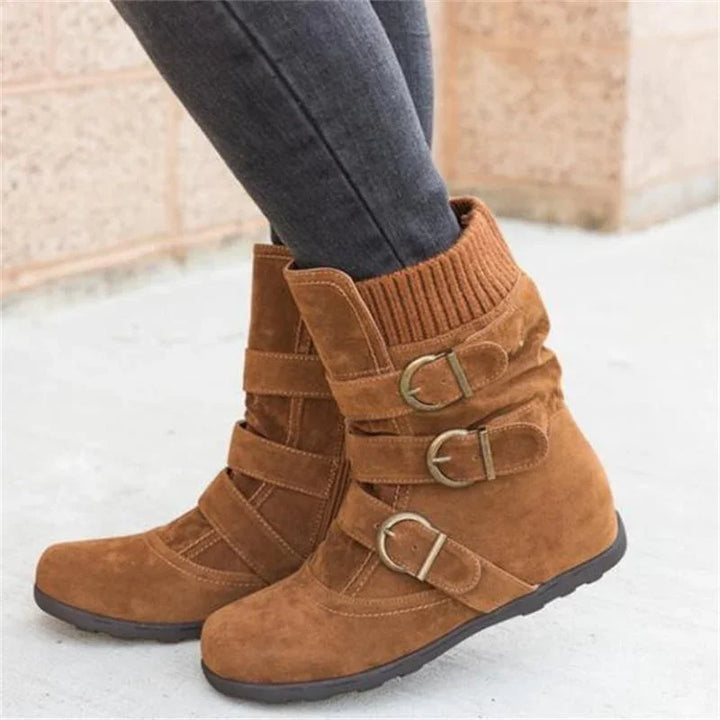 Women wearing brown suede ankle boots with three buckle straps and knitted cuffs