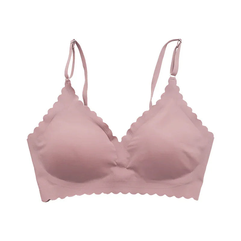 Soft pink scalloped edge wireless bra with adjustable straps on white background