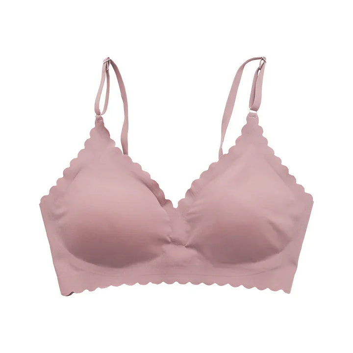 Soft pink scalloped edge wireless bra with adjustable straps on white background