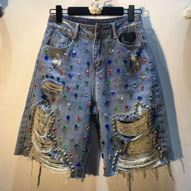 Distressed denim shorts embellished with colorful rhinestones and silver ball chain accents