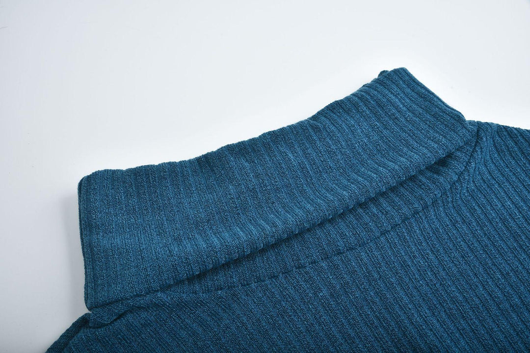 Close-up of blue ribbed knit fabric collar on a folded garment against white background