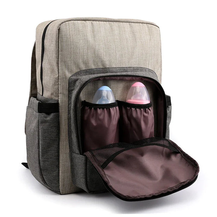 Beige and gray backpack with front pocket holding two baby bottles with blue and pink lids