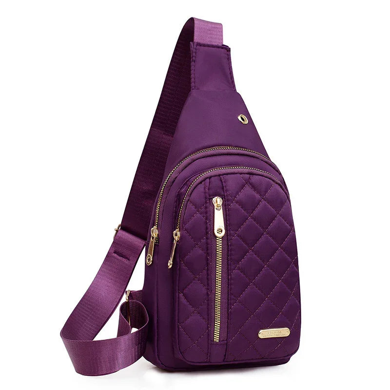 Purple quilted sling backpack with gold zippers and adjustable shoulder strap