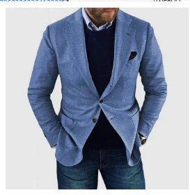 man wearing light blue blazer over navy sweater and white shirt with blue jeans