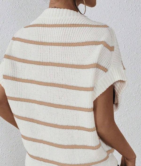 Back view of woman wearing beige and white striped knitted sleeveless sweater against white wall