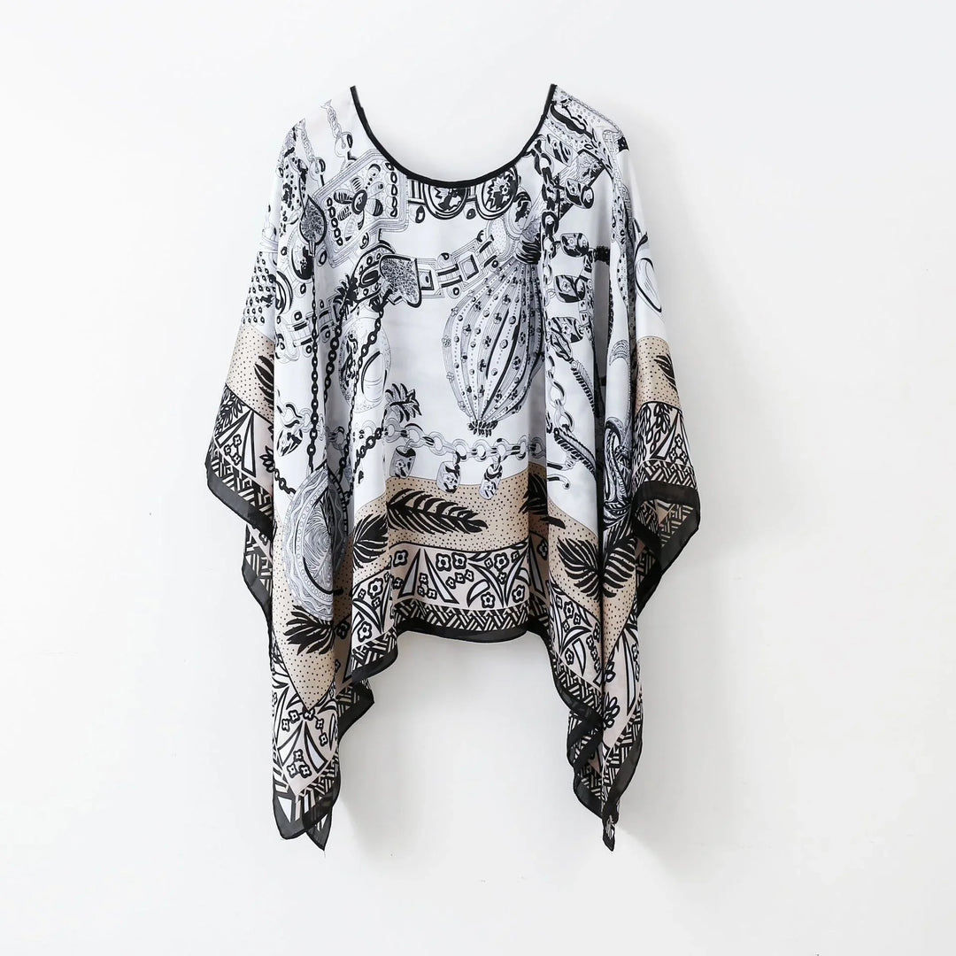 Black and beige patterned asymmetrical poncho top with intricate chain and leaf designs