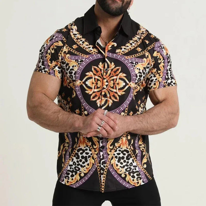 Man wearing a short-sleeve black button-up shirt with gold baroque and leopard print patterns