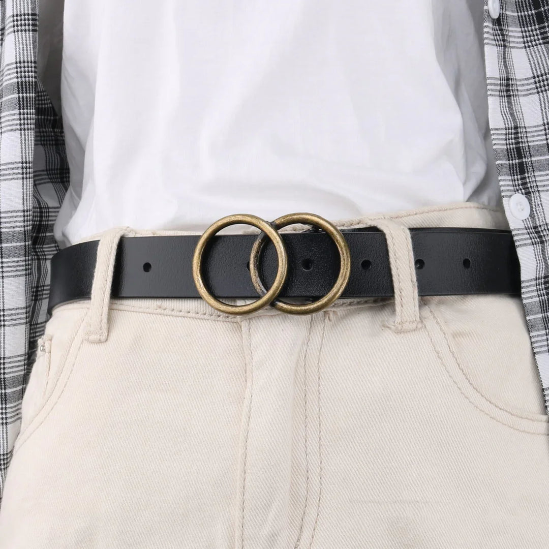 Black leather belt with double brass ring buckle worn with beige pants and white shirt