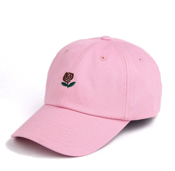Pink baseball cap with small embroidered brown rose and green leaves on front