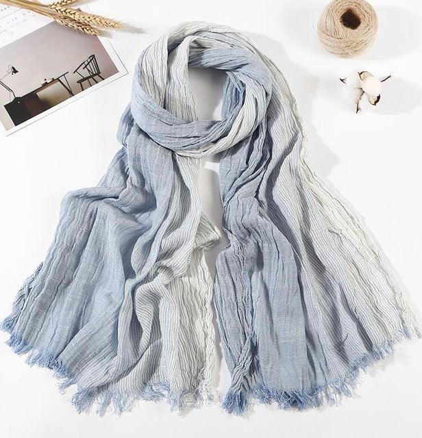 Light blue and white gradient cotton scarf with crinkled texture and fringed edges displayed on white surface