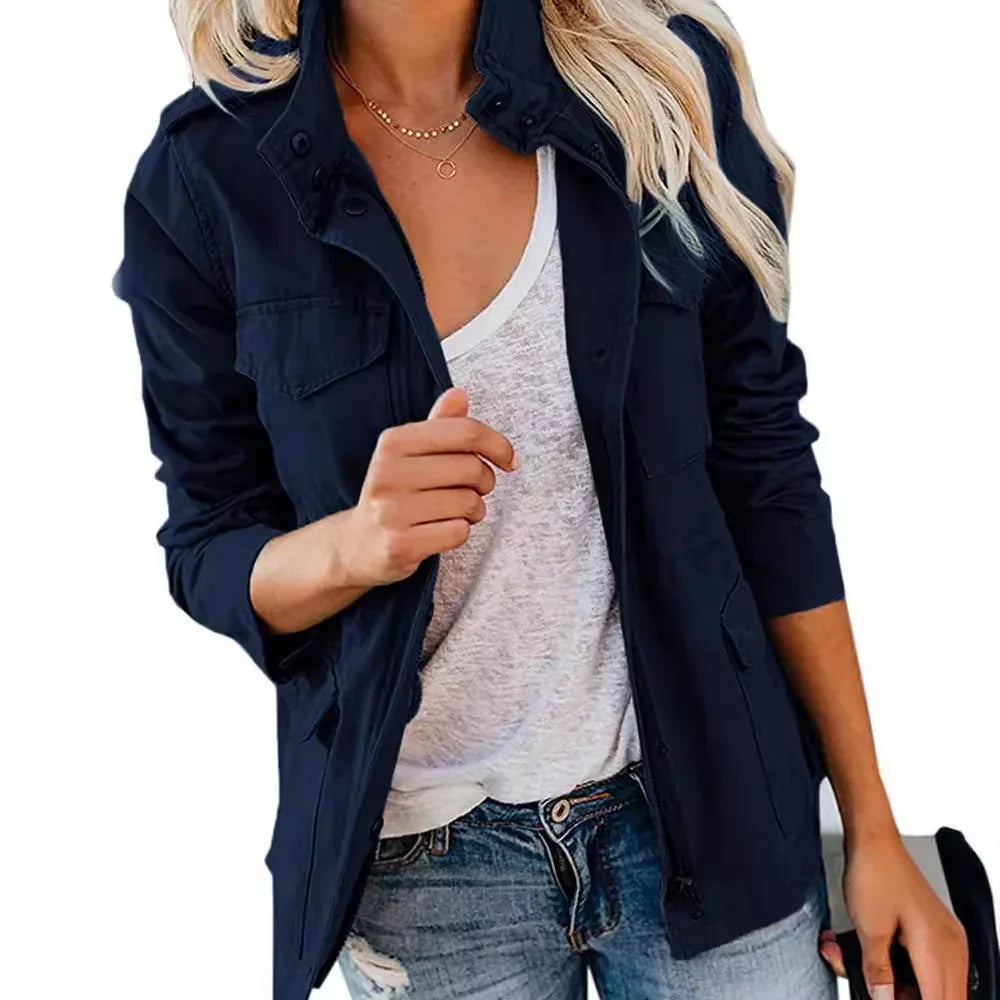 Woman wearing navy blue casual jacket over white t-shirt and distressed jeans, holding black hat