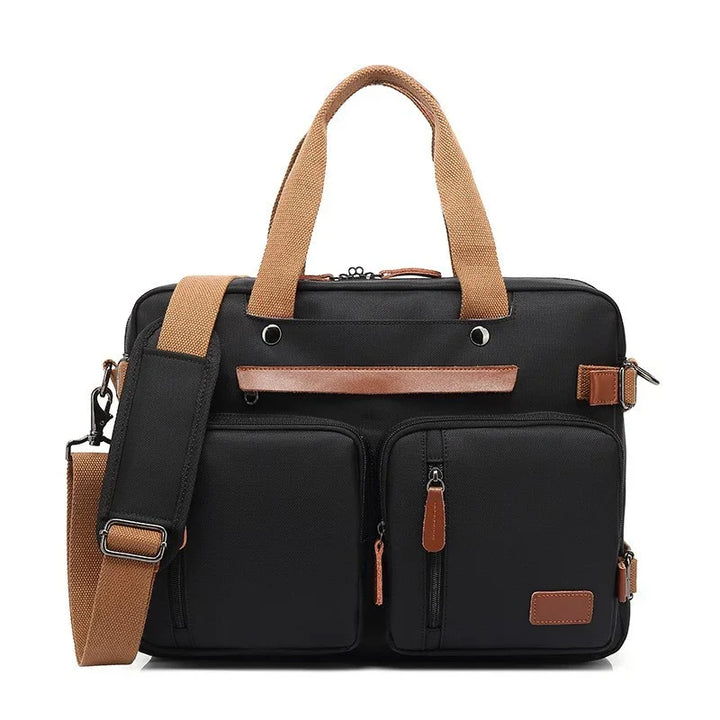 Black laptop bag with brown handles, leather accents, and front zippered pockets with adjustable shoulder strap
