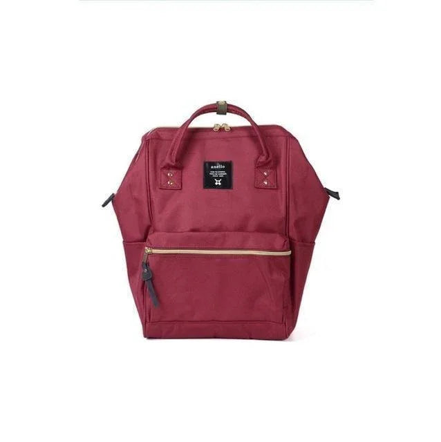 Red Anello backpack with top handles and front zipper pocket on white background