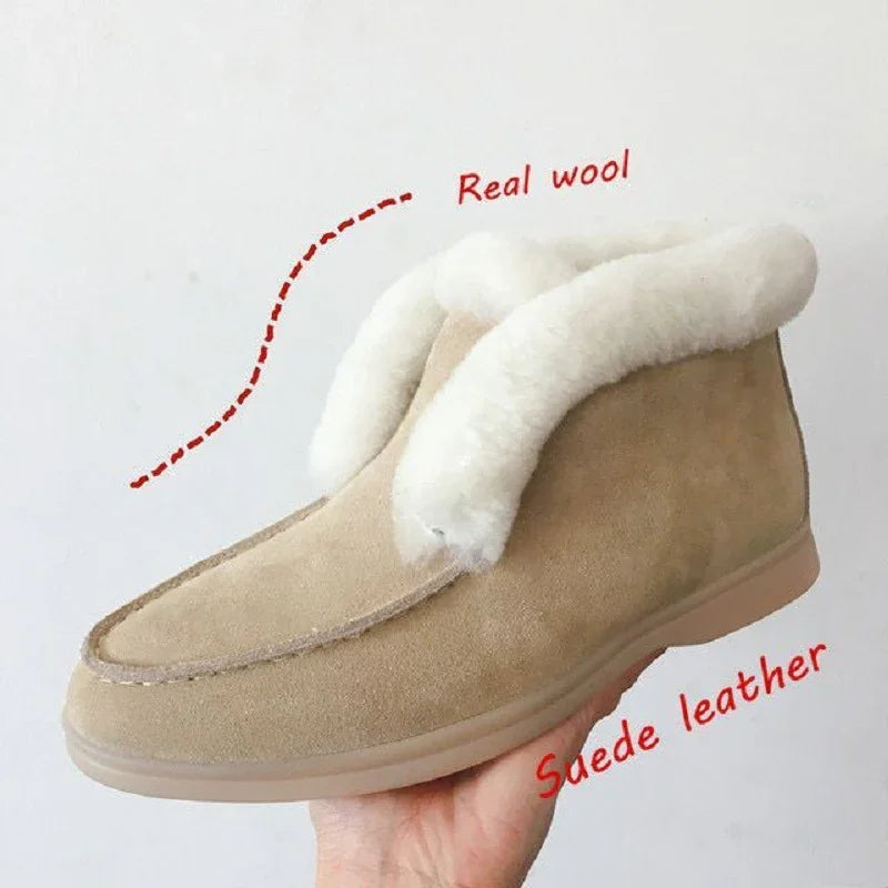 Hand holding beige suede leather slipper with real wool lining on white background