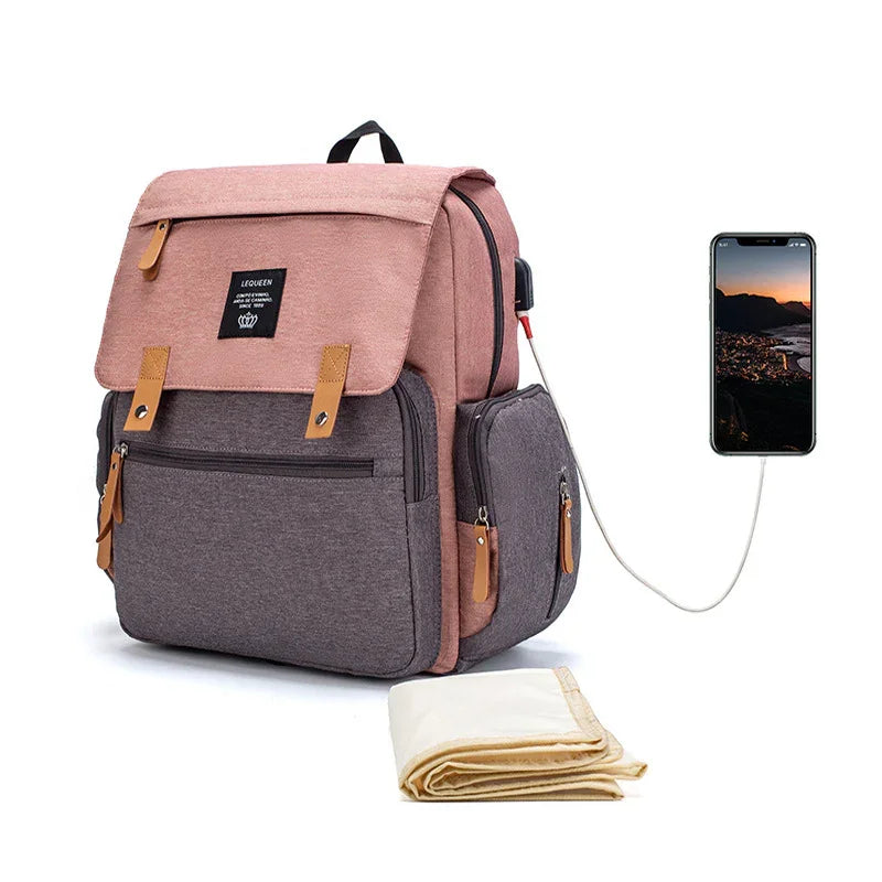 pink and gray backpack with leather accents and USB charging port connected to smartphone