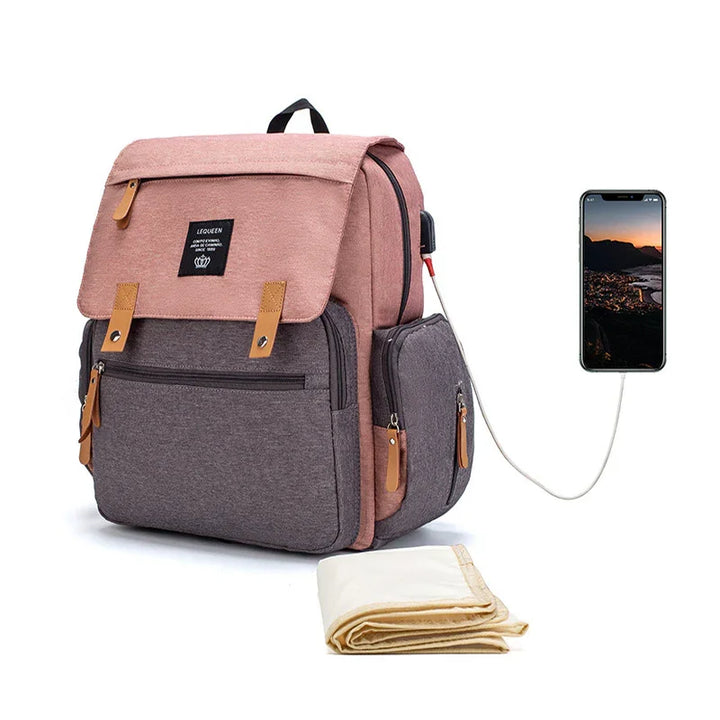 pink and gray backpack with leather accents and USB charging port connected to smartphone