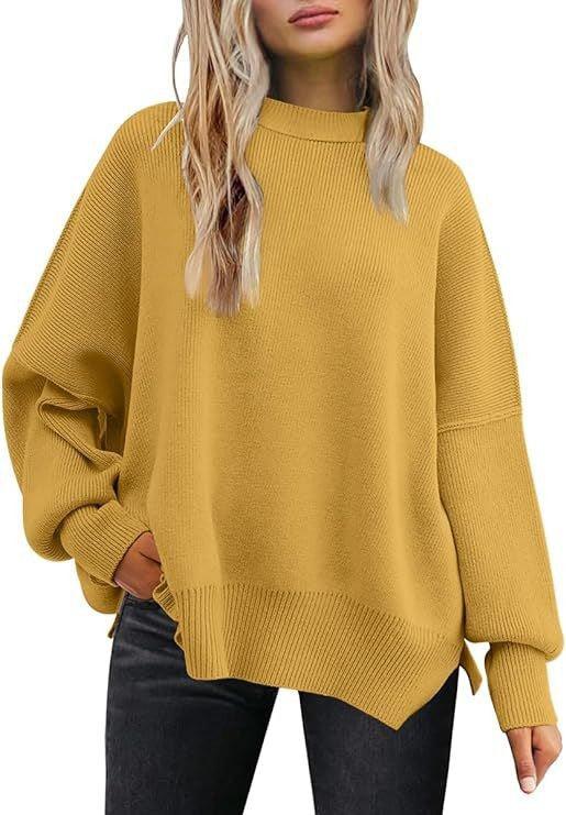 Woman wearing an oversized mustard yellow knit sweater with balloon sleeves and ribbed cuffs, paired with black jeans