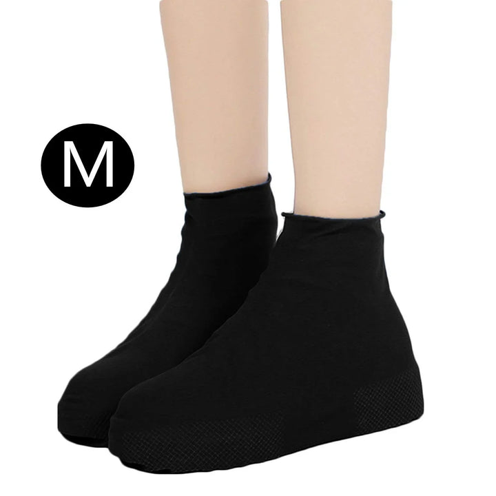 Pair of black waterproof shoe covers with medium size label on light skin legs