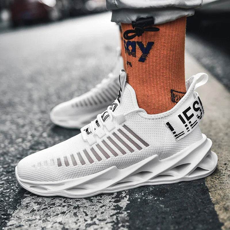 White modern athletic sneakers with unique sole design worn with orange socks on asphalt road