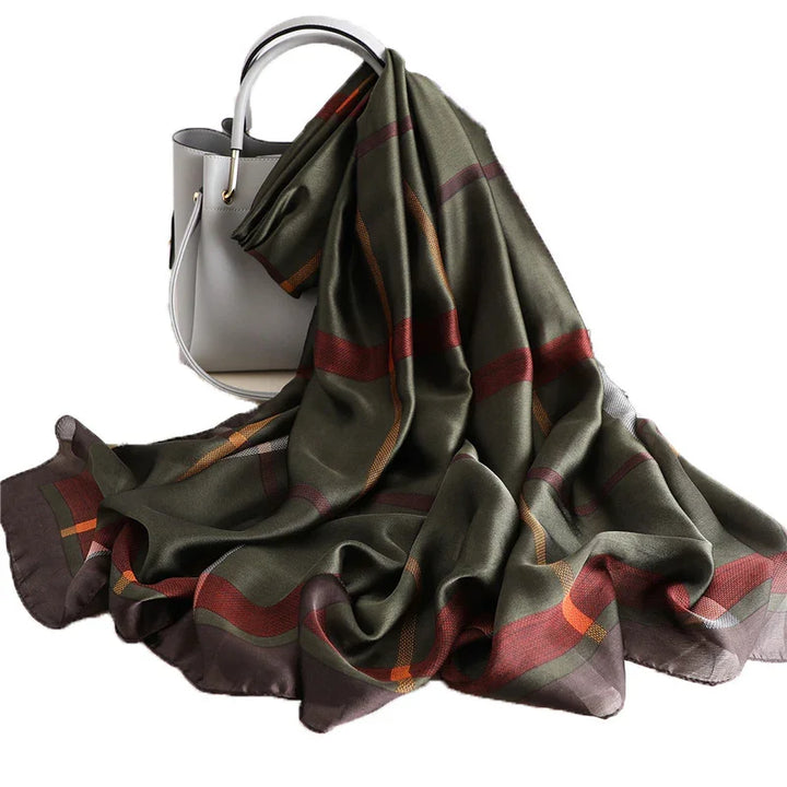 Olive green scarf with red and orange stripes draped over gray handbag with round handles