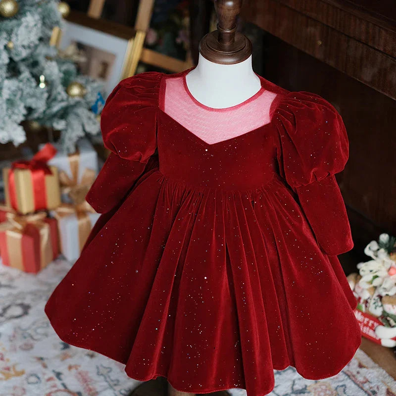 Red velvet toddler dress with puff sleeves and glitter on mannequin, Christmas gifts and tree background