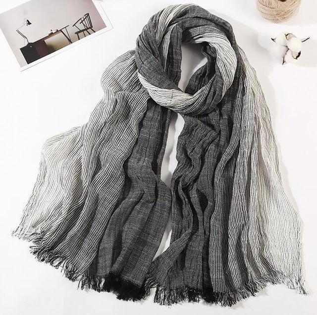 Soft lightweight scarf with black and white vertical stripes and fringed edges, styled on white background