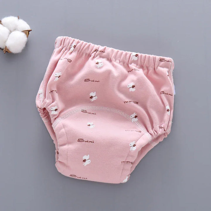 Pink baby training pants with white bunny print and elastic waist on gray background