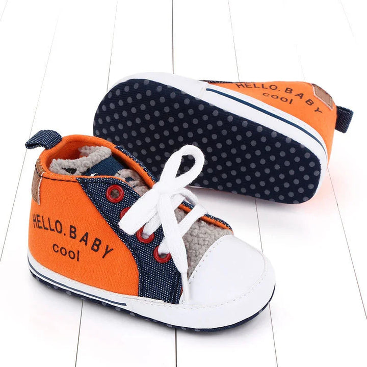 Orange and navy baby shoes with white laces and soles, text 'HELLO BABY cool' on side, soft interior