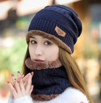 Woman wearing navy blue knit beanie and matching scarf with brown faux fur trim outdoors