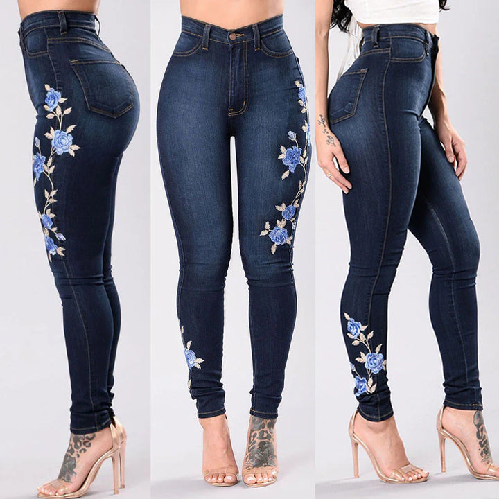 Dark blue skinny jeans with blue floral embroidery on sides worn with clear high heels