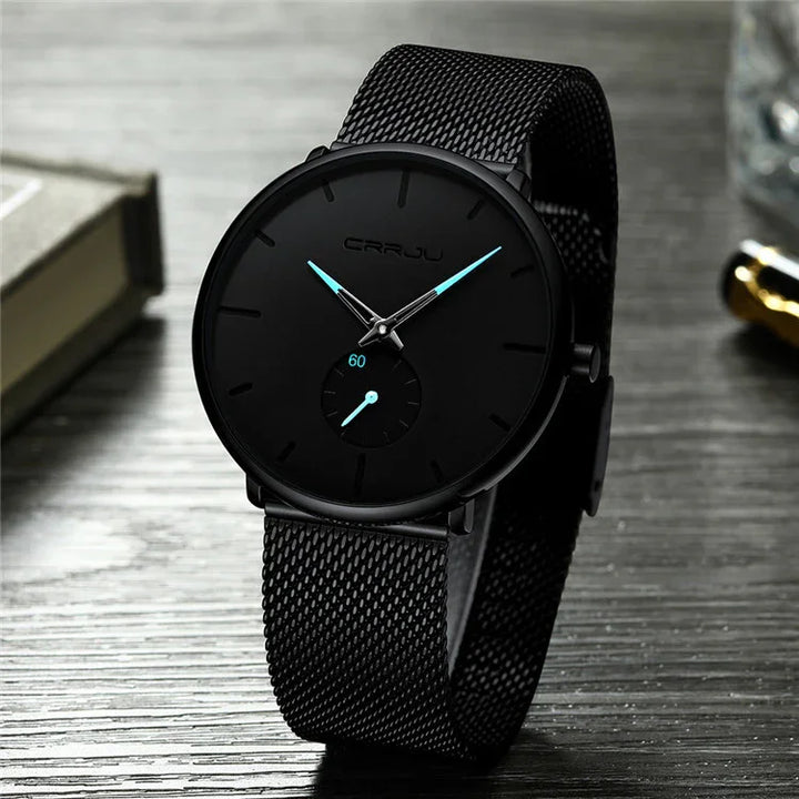 CRRJU black minimalist wristwatch with mesh strap and blue-tipped hands on wooden surface