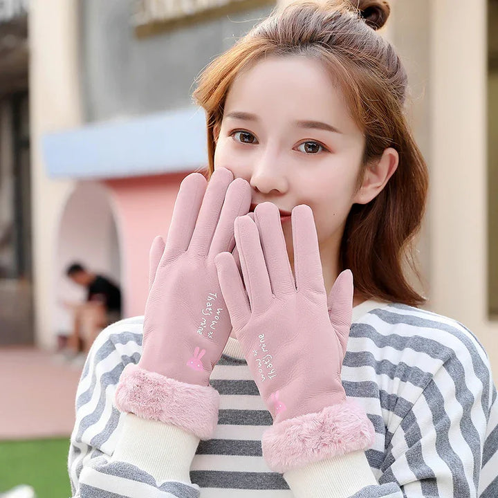Woman wearing pink fleece-lined gloves with bunny print and white striped sweater outdoors