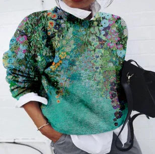 Woman wearing green floral patterned sweater layered over white shirt holding black handbag