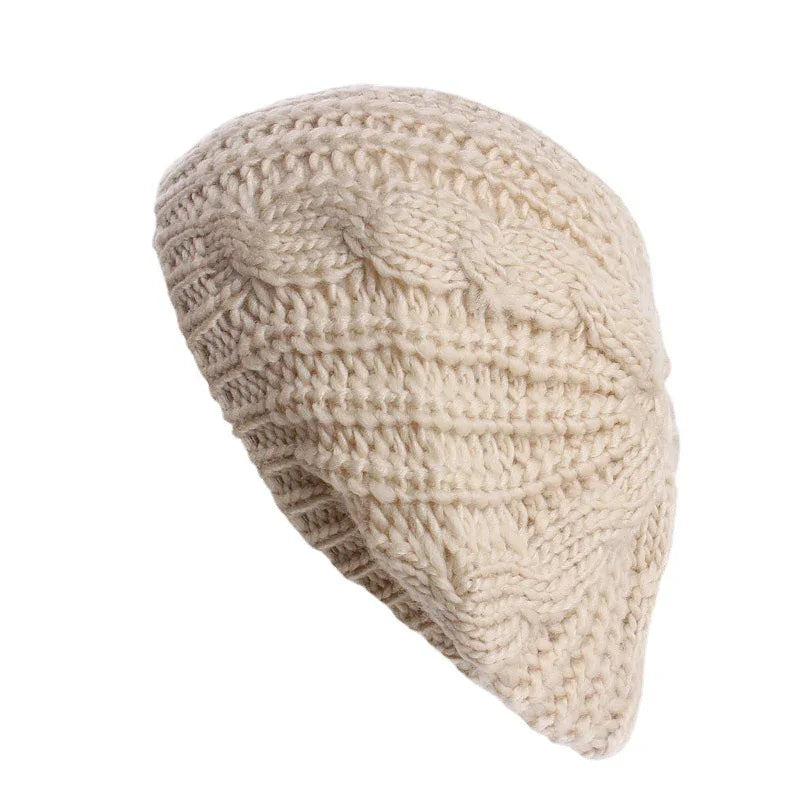 Cream-colored chunky knit beanie with braided cable pattern on white background