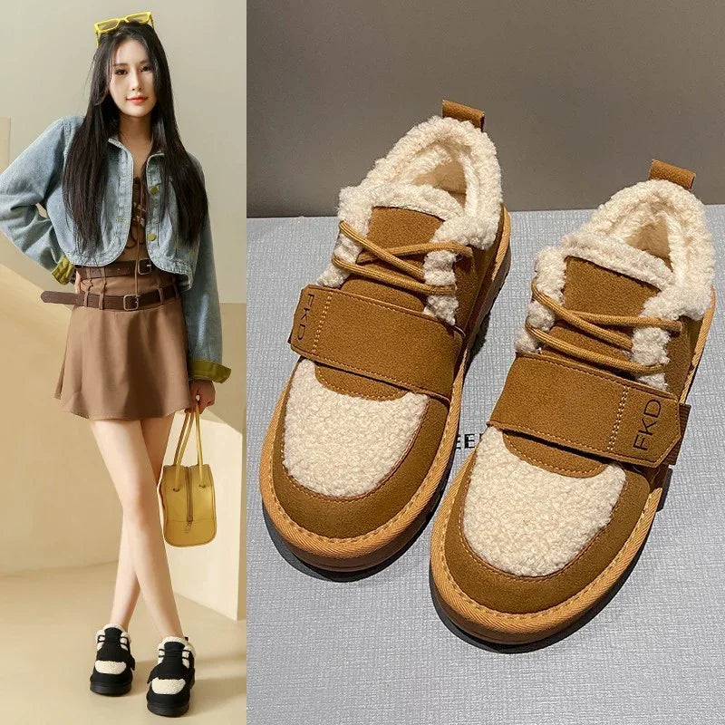 Brown and cream sherpa fleece sneakers with velcro strap, worn by model in brown dress and cropped denim jacket