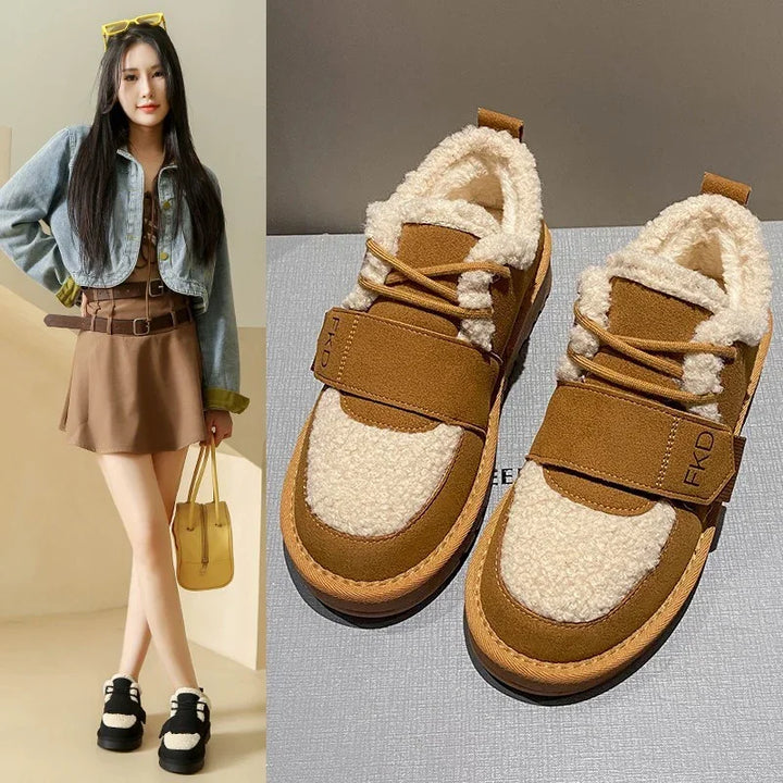 Brown and cream sherpa fleece sneakers with velcro strap, worn by model in brown dress and cropped denim jacket