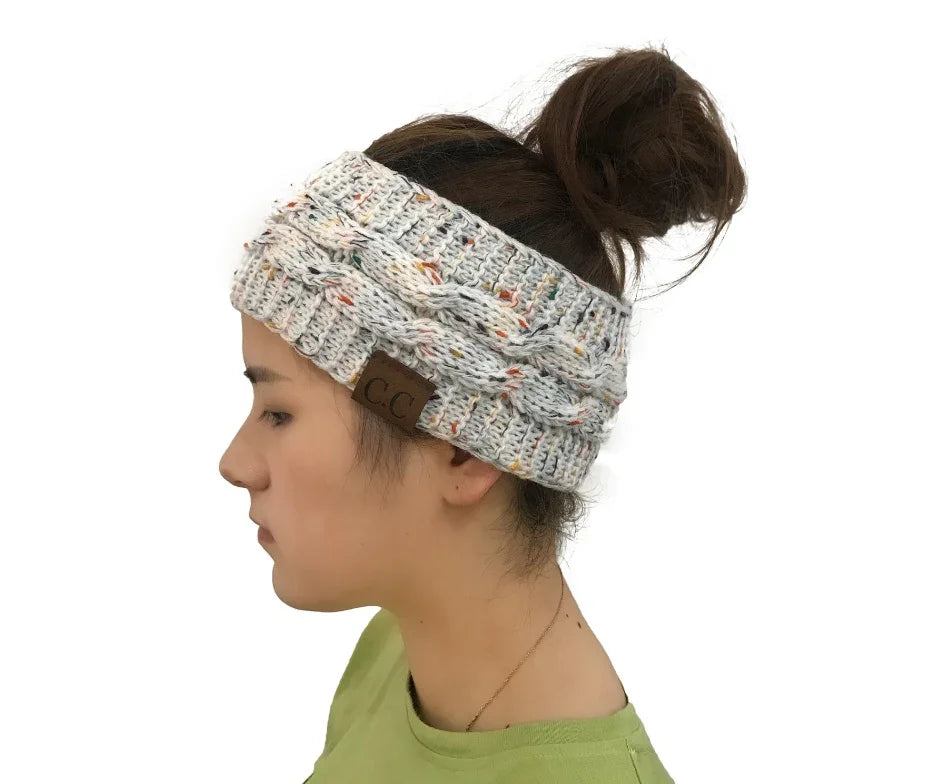 Woman wearing a speckled knit cable headband with C.C brand label and a messy bun hairstyle