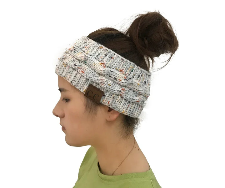 Woman wearing a speckled knit cable headband with C.C brand label and a messy bun hairstyle