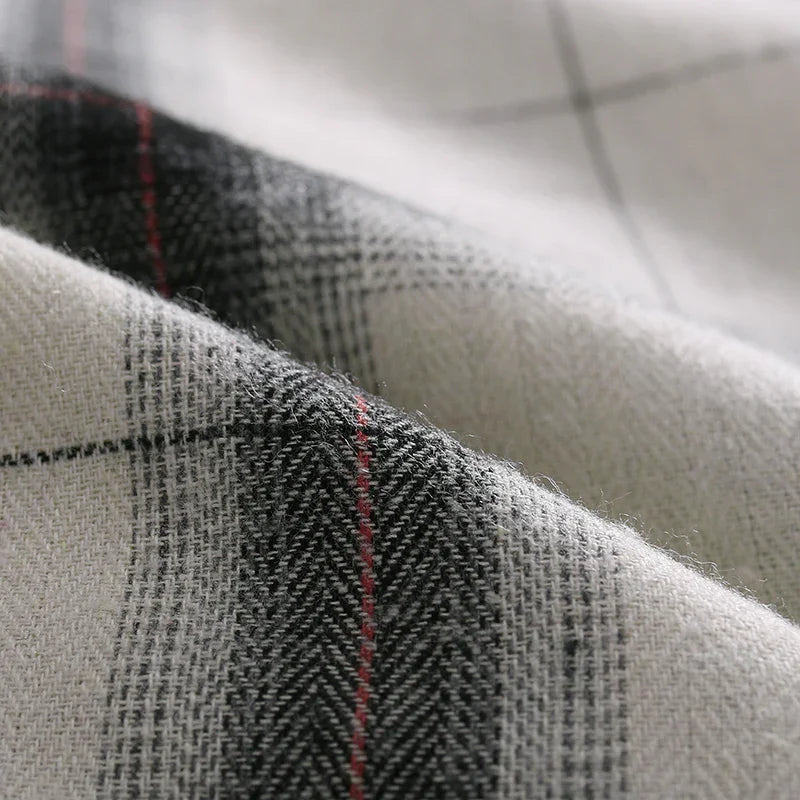 Close-up of soft woven fabric with black, white, and red plaid pattern and textured fibers