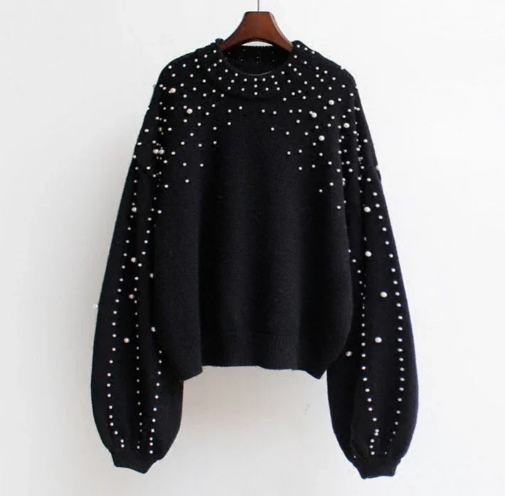 Black knitted sweater with scattered white pearl embellishments on sleeves and chest, ribbed cuffs