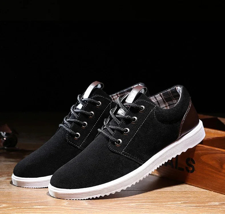 Black casual lace-up sneakers with white outsole and plaid inner lining on wooden floor