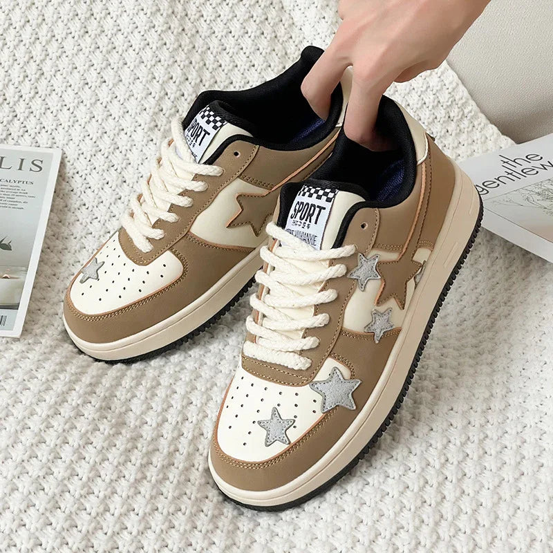 Beige and white sneakers with star-shaped decorations and white laces on a textured rug