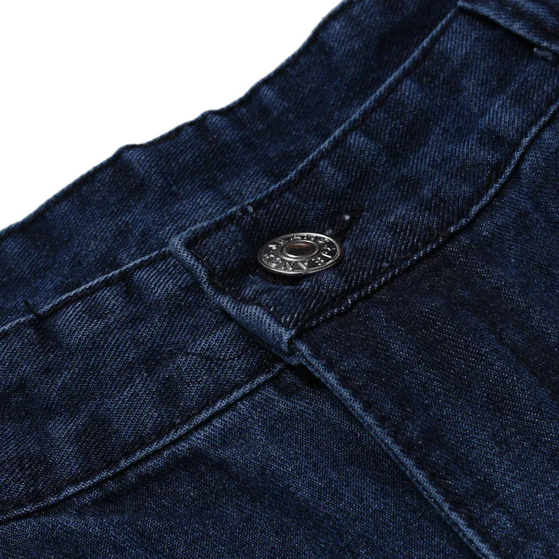 Close-up of dark blue denim jeans with metallic button and detailed stitching